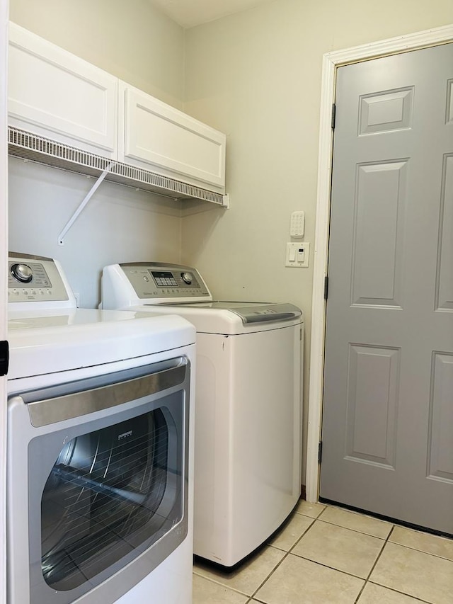 laundry room featuring washer and dryer, laundry area, and light tile patterned floors