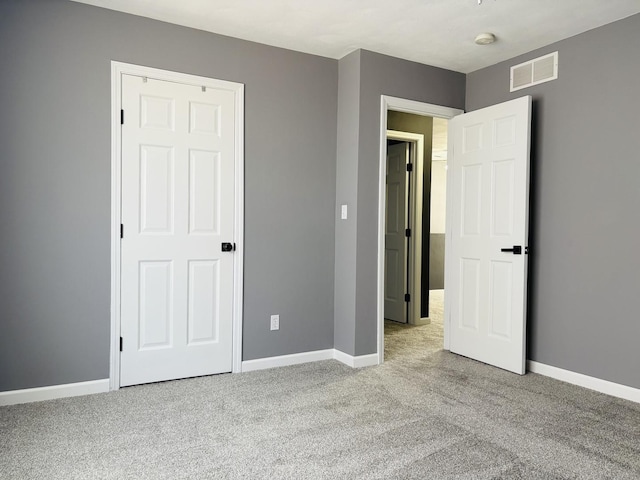 unfurnished bedroom featuring visible vents, carpet floors, and baseboards