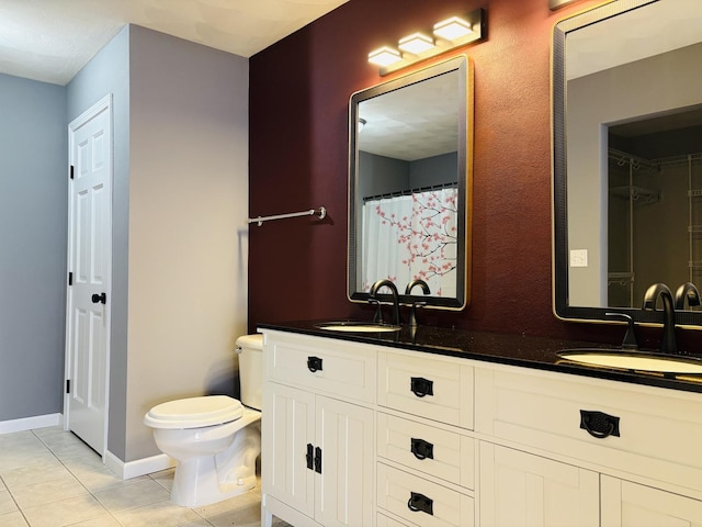 full bathroom featuring a sink, toilet, double vanity, and tile patterned flooring