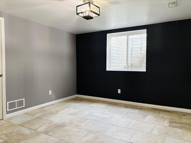 unfurnished room with visible vents and baseboards