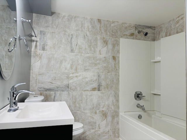 bathroom with toilet, tile walls, shower / washtub combination, and vanity