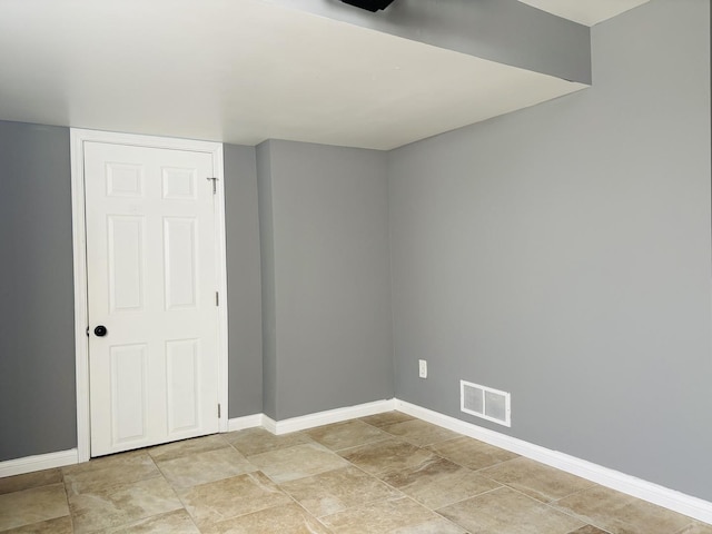 empty room featuring baseboards and visible vents