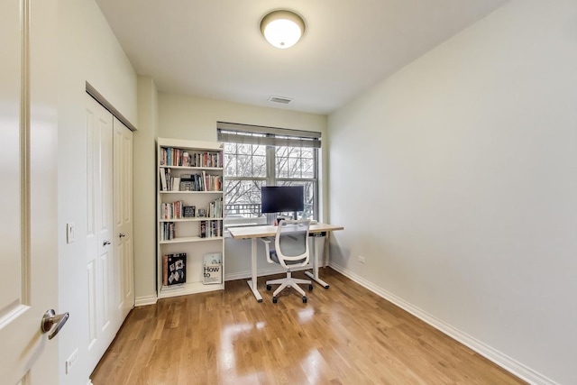 home office featuring visible vents, baseboards, and wood finished floors