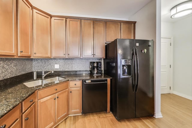 kitchen featuring a sink, decorative backsplash, light wood-style floors, and black appliances