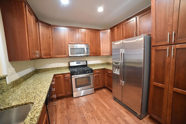 kitchen featuring light wood finished floors, light stone countertops, recessed lighting, brown cabinets, and stainless steel appliances