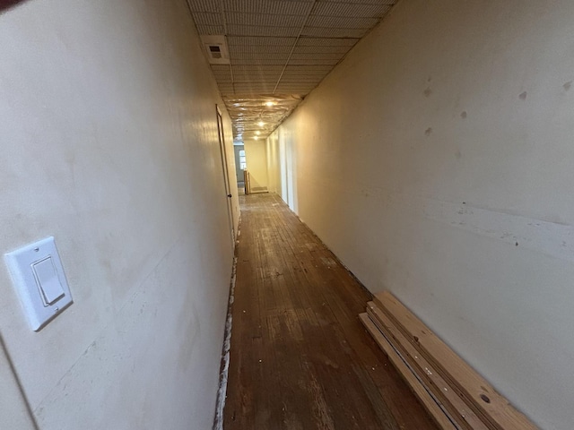 hallway featuring visible vents, a paneled ceiling, and hardwood / wood-style flooring