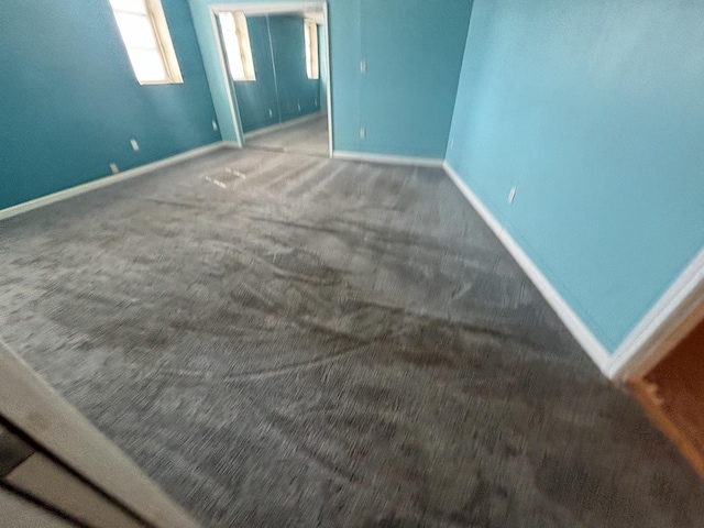 unfurnished bedroom featuring baseboards and carpet floors