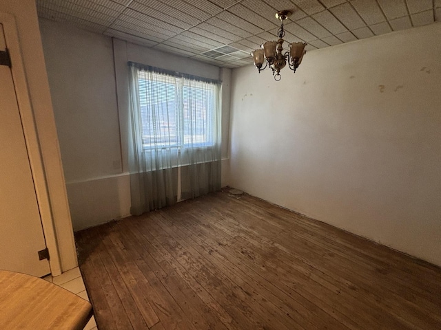 unfurnished dining area with an inviting chandelier and hardwood / wood-style floors