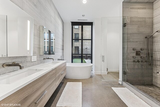 full bathroom featuring a shower stall, a freestanding bath, and a sink