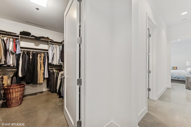 corridor featuring recessed lighting, baseboards, and concrete flooring