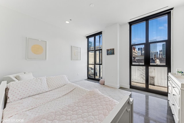 bedroom with access to exterior, baseboards, finished concrete floors, floor to ceiling windows, and recessed lighting