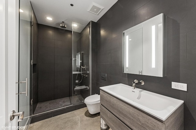 bathroom featuring visible vents, toilet, a stall shower, tile walls, and vanity