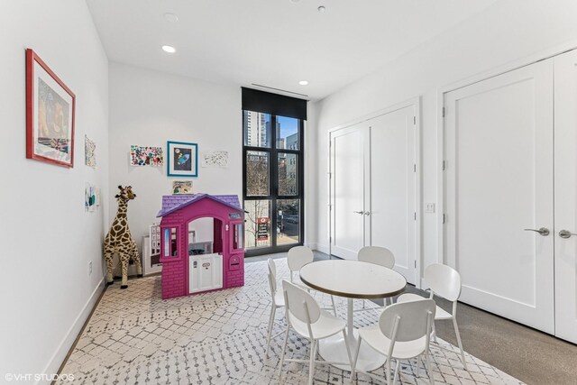 rec room with recessed lighting, a wall of windows, and baseboards