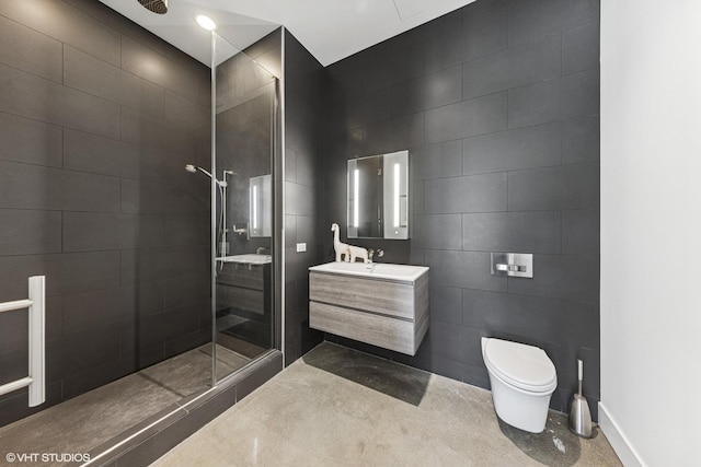 full bathroom featuring tiled shower, toilet, tile walls, and vanity