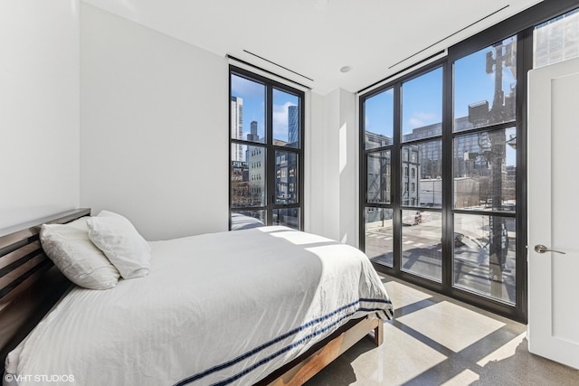 bedroom featuring a view of city and floor to ceiling windows