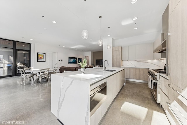 kitchen featuring stainless steel range, recessed lighting, modern cabinets, and a sink