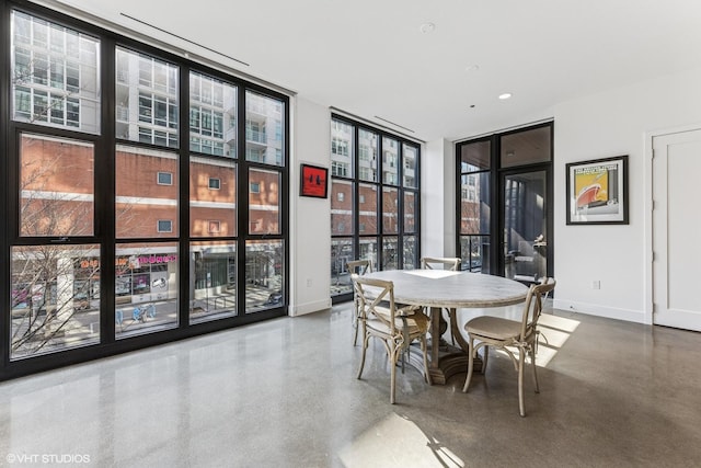 dining room with plenty of natural light, baseboards, and expansive windows