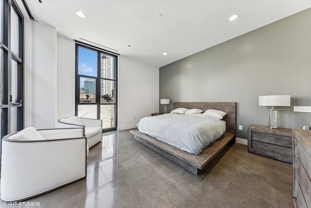 bedroom featuring finished concrete floors, recessed lighting, a wall of windows, and baseboards