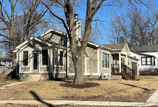 view of front of property with a garage, a chimney, and fence