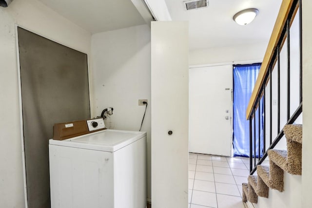 clothes washing area featuring visible vents, washer / dryer, light tile patterned flooring, and laundry area