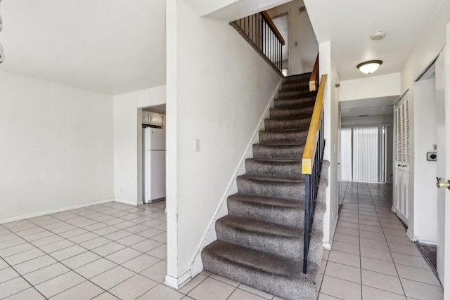 stairway featuring tile patterned floors and baseboards