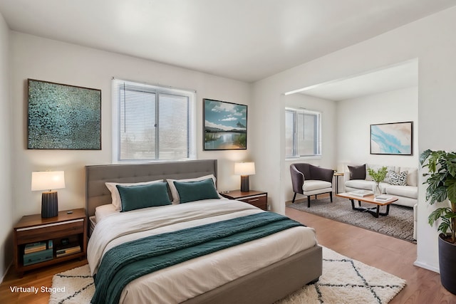 bedroom with multiple windows and wood finished floors