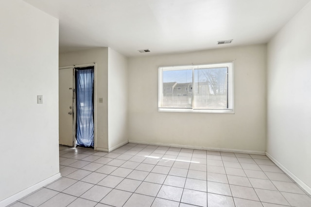 spare room with light tile patterned floors, visible vents, and baseboards