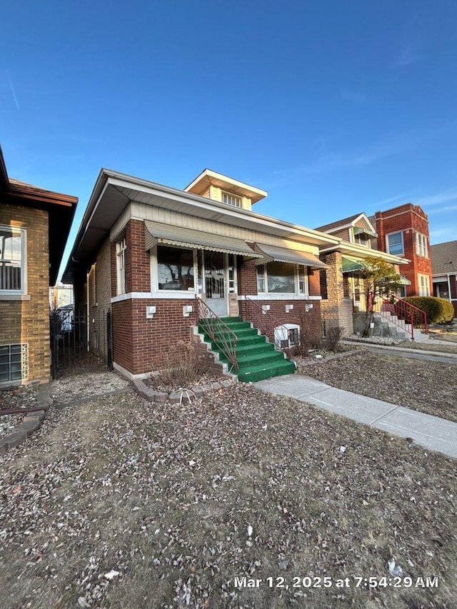 view of front of property with entry steps, fence, and brick siding