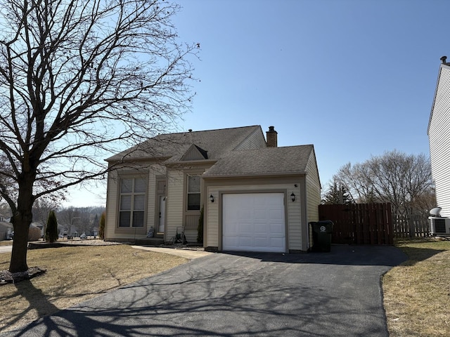 view of front of property with a shingled roof, fence, aphalt driveway, a chimney, and an attached garage