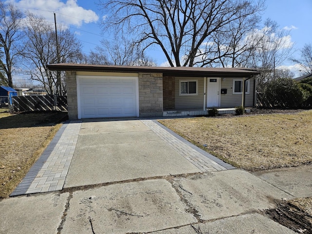 single story home featuring stone siding, an attached garage, concrete driveway, and fence