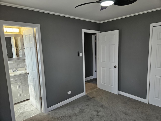 unfurnished bedroom with a sink, baseboards, carpet floors, and ornamental molding