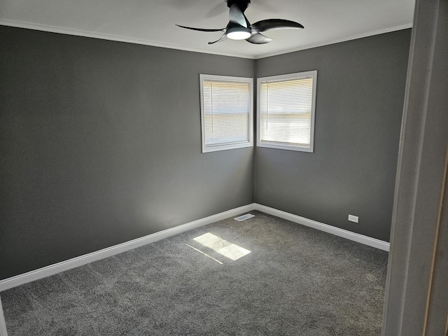 spare room with visible vents, ornamental molding, a ceiling fan, carpet floors, and baseboards