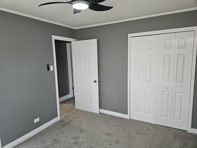 unfurnished bedroom featuring a closet, baseboards, carpet, and ornamental molding