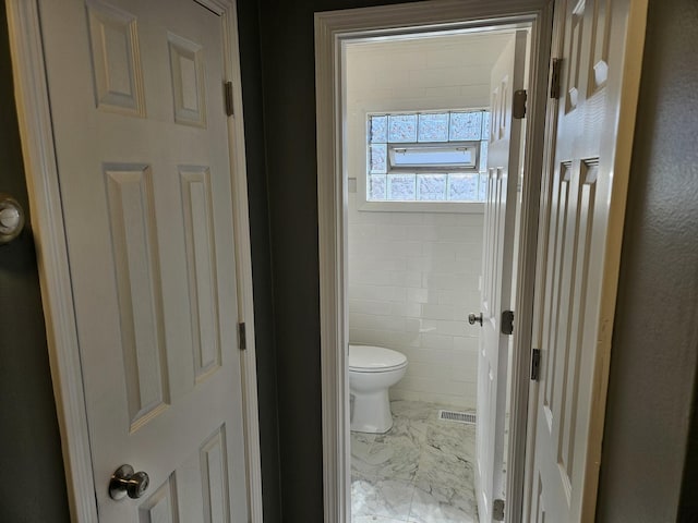 bathroom featuring visible vents, marble finish floor, and toilet