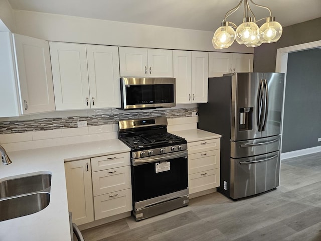 kitchen featuring a sink, light countertops, backsplash, and stainless steel appliances