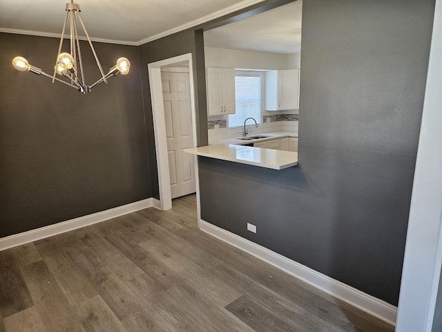 dining space with an inviting chandelier, wood finished floors, baseboards, and ornamental molding