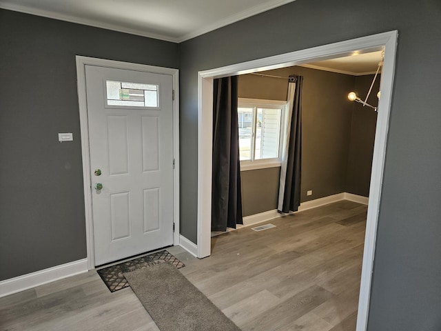 entryway with baseboards, light wood-style floors, and ornamental molding