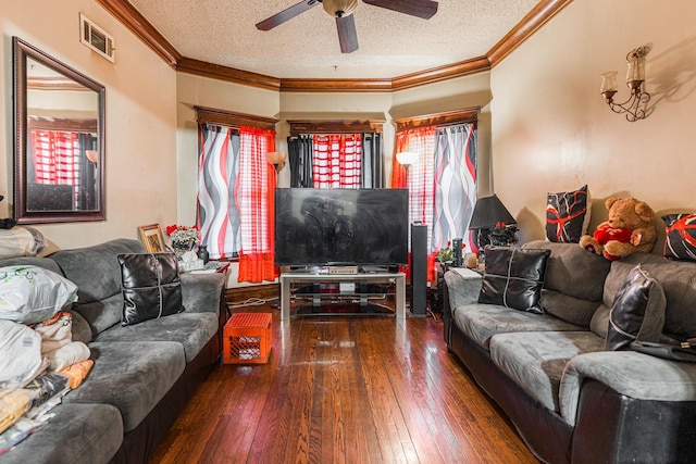 living area with hardwood / wood-style floors, visible vents, a textured ceiling, and ornamental molding