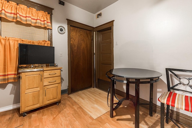 dining space with light wood-style flooring, baseboards, and visible vents