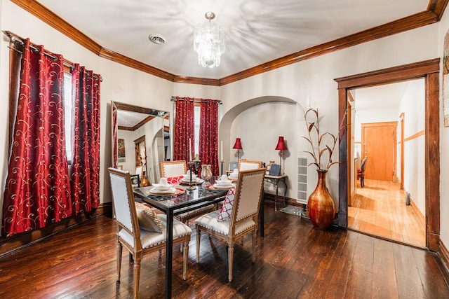 dining area with visible vents, a notable chandelier, ornamental molding, hardwood / wood-style floors, and baseboards