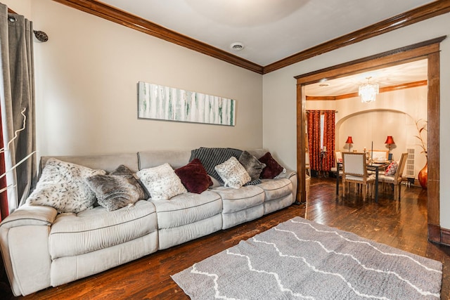 living room featuring hardwood / wood-style floors, crown molding, a notable chandelier, and visible vents