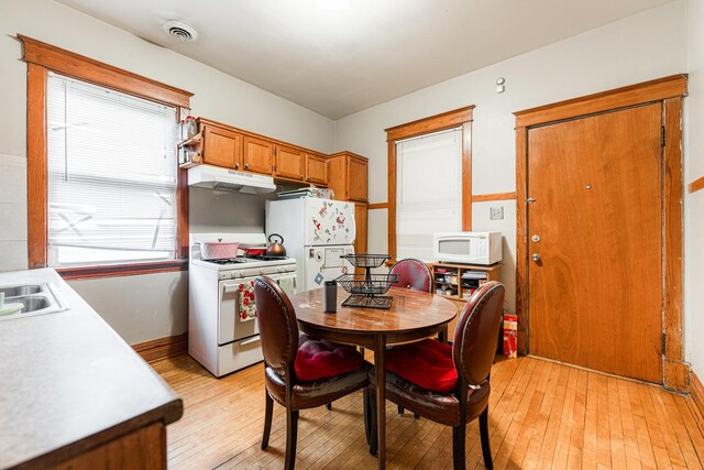 dining room featuring light wood-style flooring, baseboards, and visible vents
