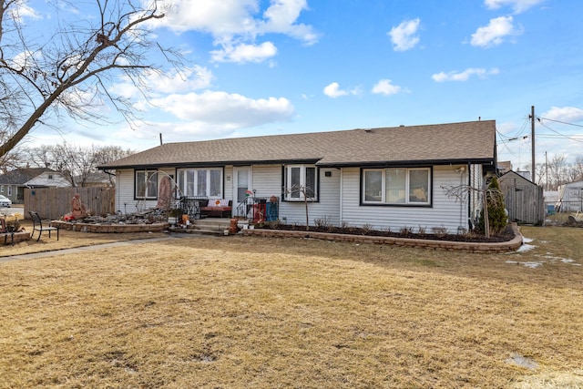 ranch-style house with roof with shingles, a front lawn, and fence