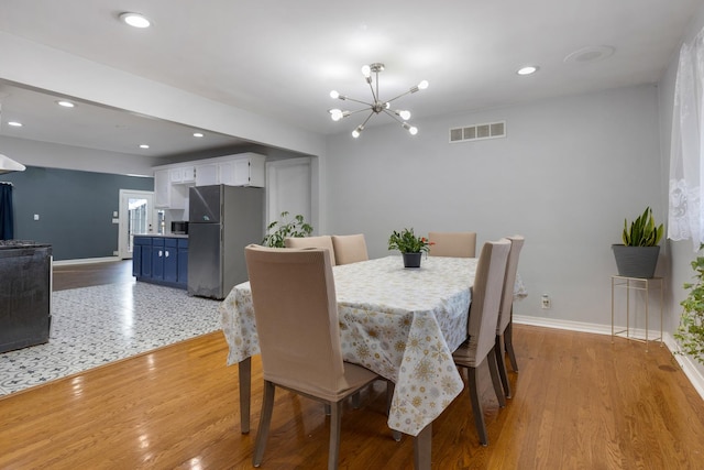 dining space featuring visible vents, baseboards, recessed lighting, light wood-style flooring, and an inviting chandelier