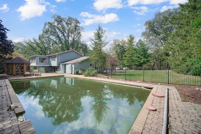 view of pool featuring a fenced in pool, fence, a gazebo, a lawn, and a patio