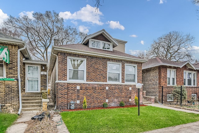 view of front of home with brick siding, a chimney, and a front lawn