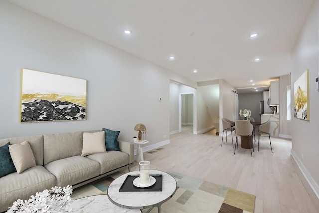 living area with visible vents, recessed lighting, baseboards, and light wood-style floors