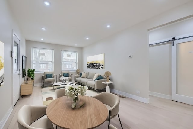 living area with visible vents, recessed lighting, baseboards, and a barn door