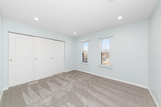 unfurnished bedroom with visible vents, baseboards, carpet floors, recessed lighting, and a closet