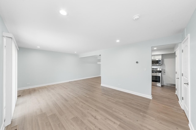 empty room with recessed lighting, baseboards, and light wood-style floors